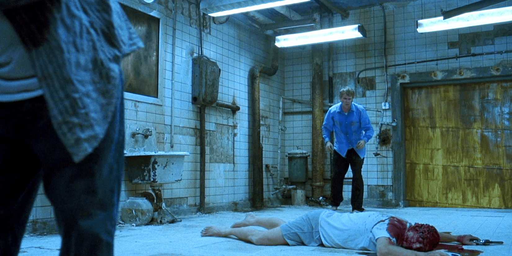 Two men look at a ᴅᴇᴀᴅ body on the floor in Saw
