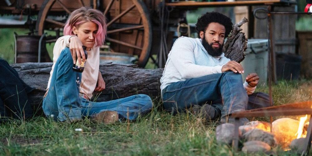 Teeter and Colby sit in the grass together on Yellowstone