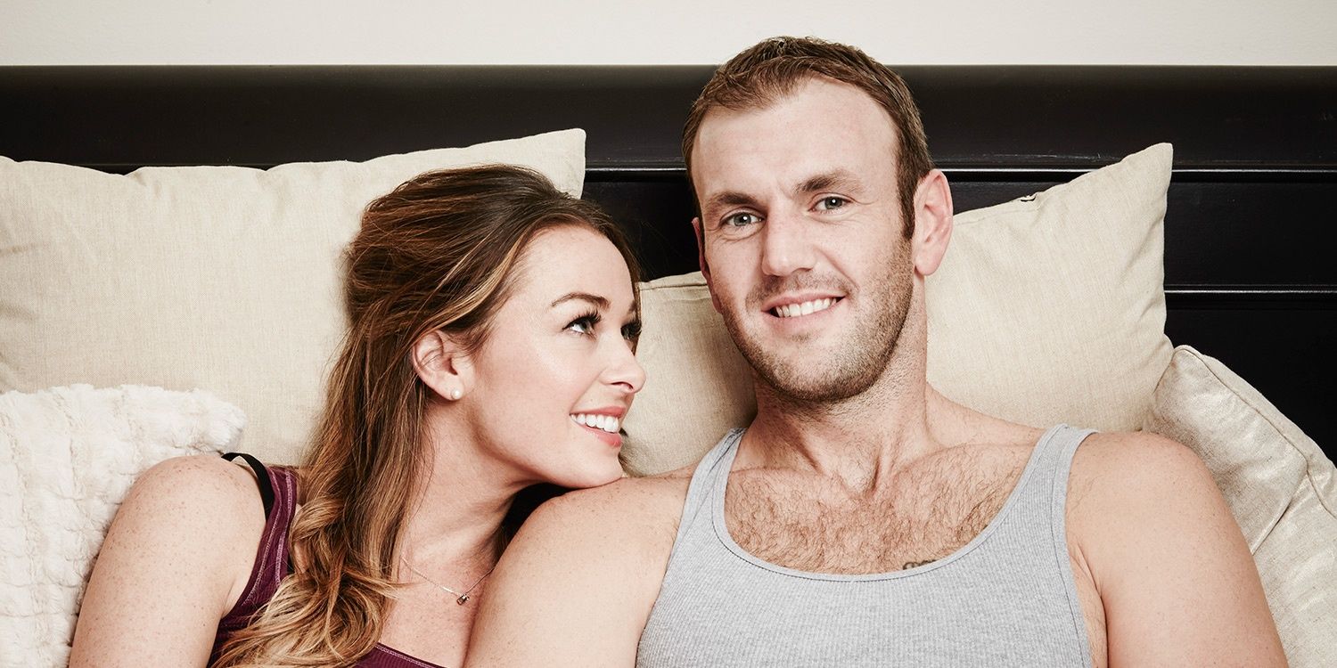 Jamie Otis Married at First Sight in pajamas together in bed with doug smiling at the camera and jamie smiling at doug