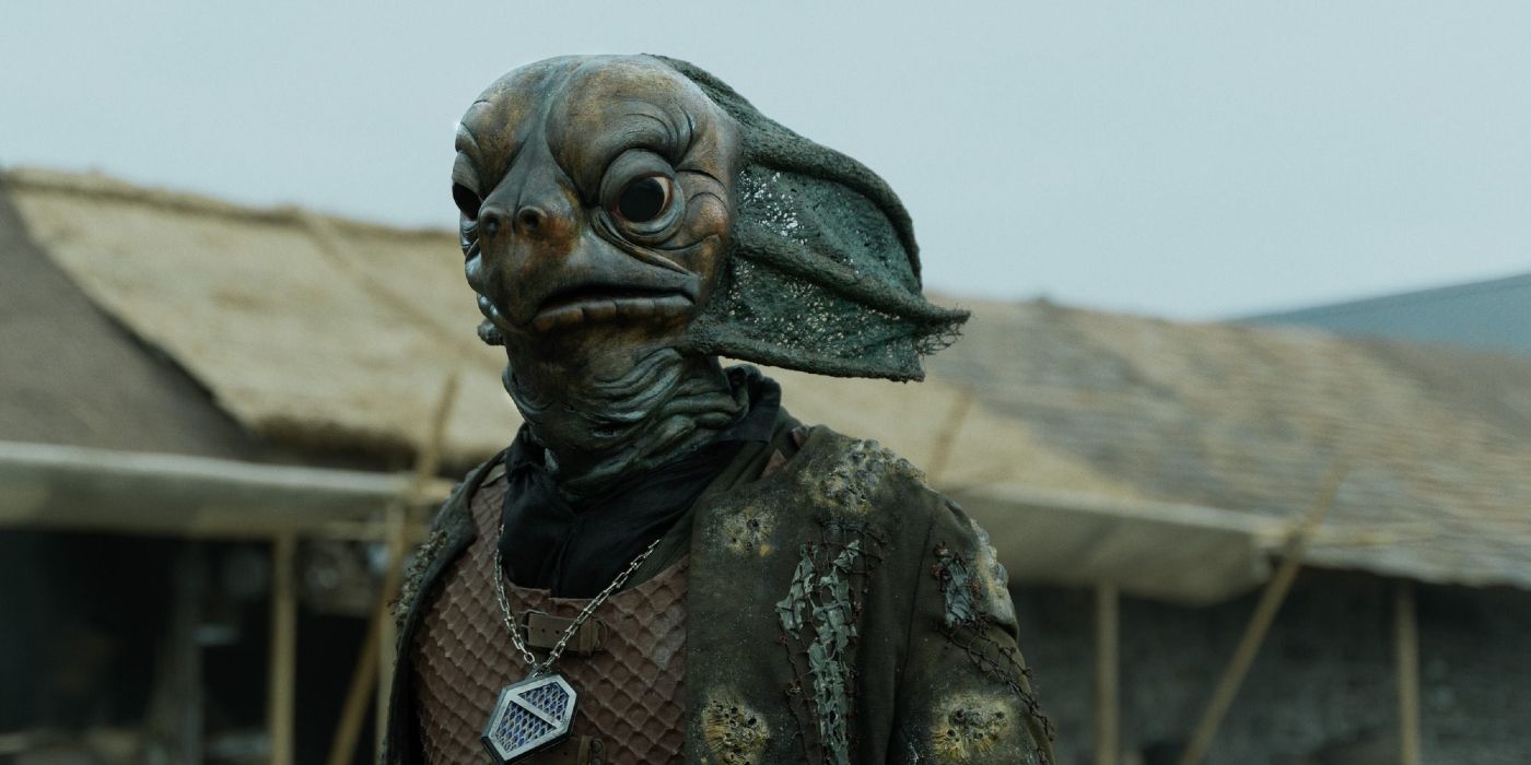 A Sea Devil looking on in a village in Doctor Who's 