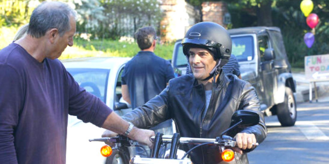 Jay helps Phil on a bike on Modern Family