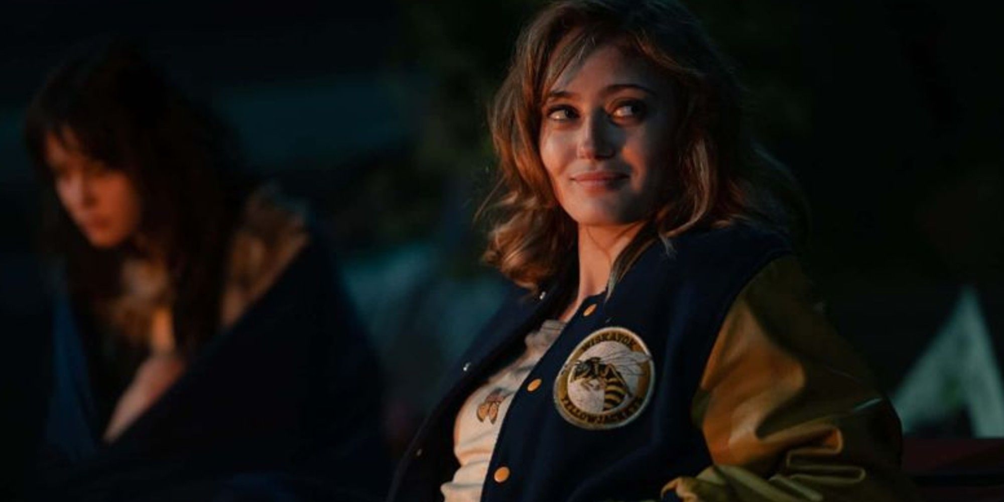 Jackie (Ella Purnell) smiling in her team jacket in Yellowjackets season 1