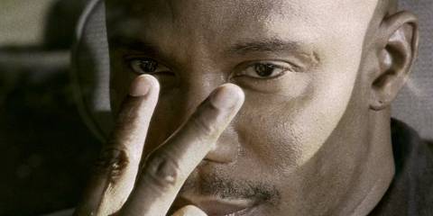 James Doakes pointing his fingers at his eyes to tell Dexter he's watching him.