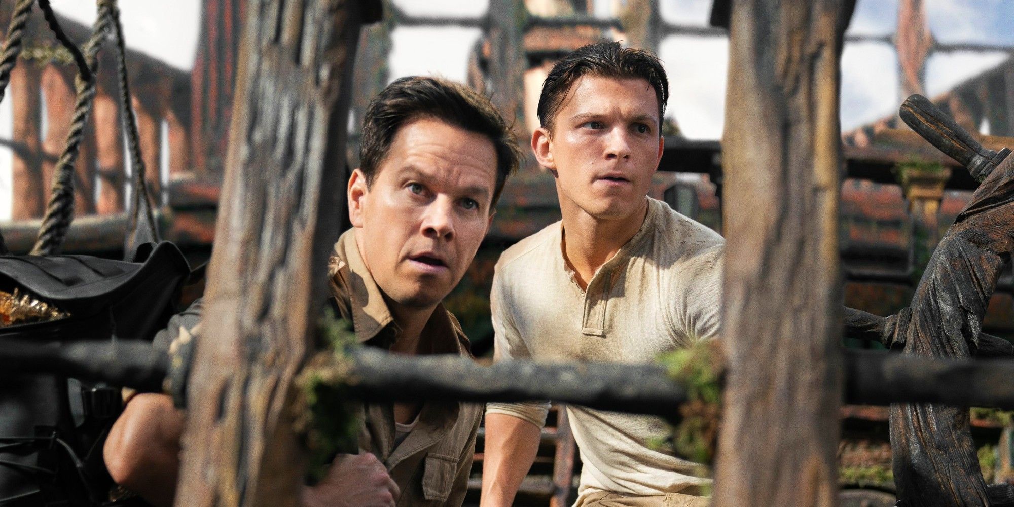 Mark Wahlberg as Sully and Tom Holland as Drake hiding on a pirate ship in Uncharted