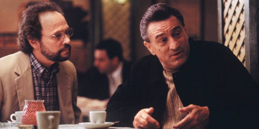 Billy Crystal and Robert De Niro sitting on a dining table in Analyze This