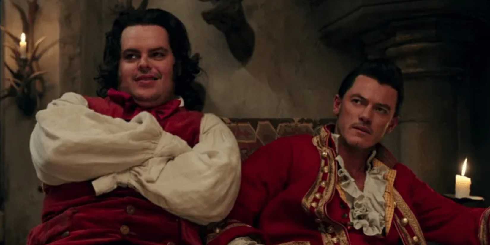 LeFou (Josh Gad) and Gaston (Luke Evans) sitting by candles in Beauty and the Beast