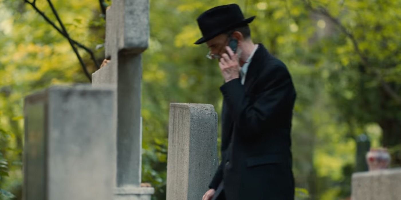 A man talks on his phone in a cemetary in Russian Doll season two.