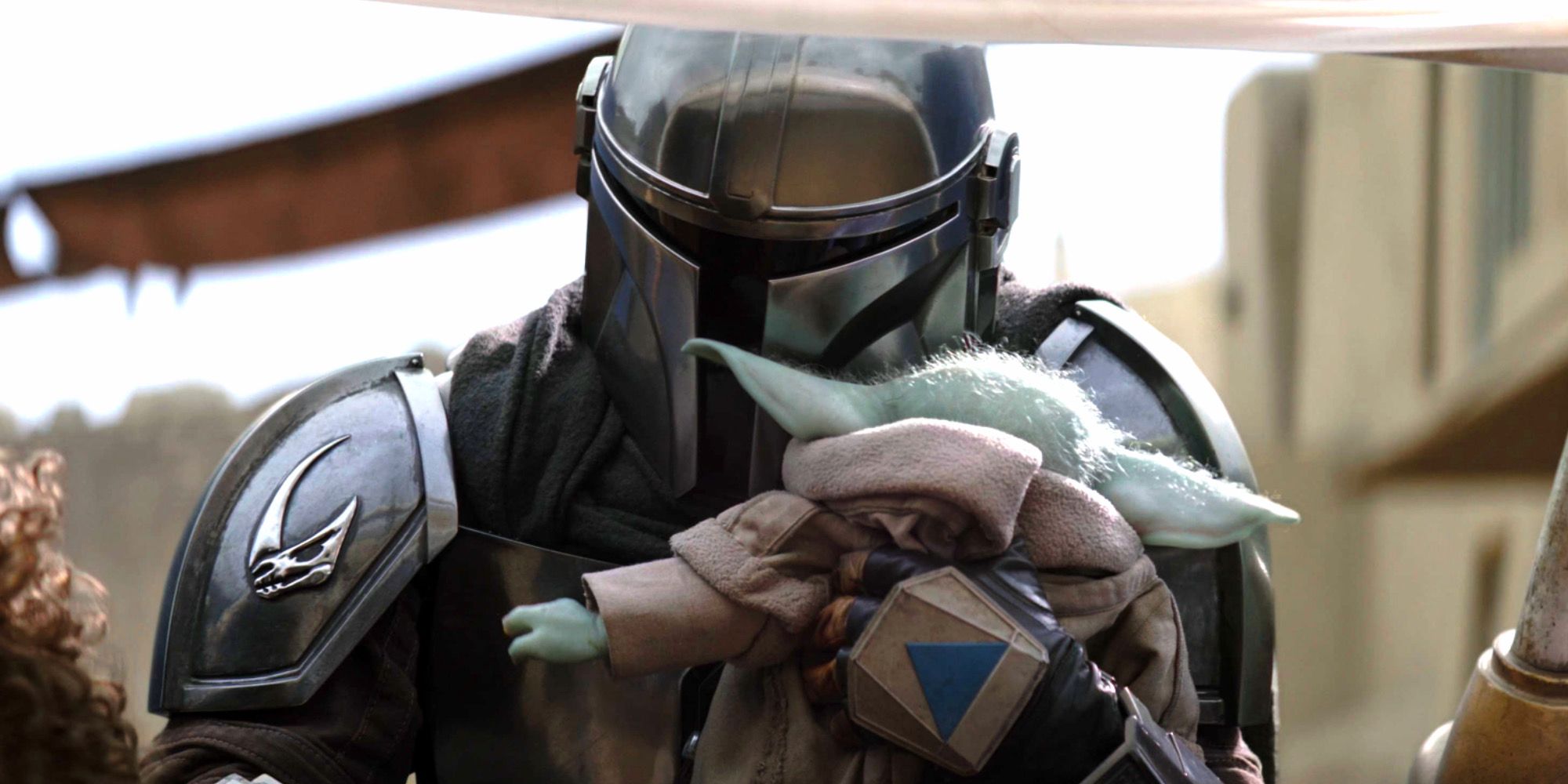 Din Djarin And Grogu In The Book Of Boba Fett Chapter 7, with Din Djarin holding Grogu