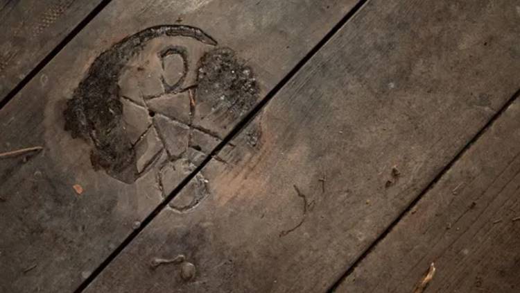 Yellowjackets Symbol carved into a floorboard
