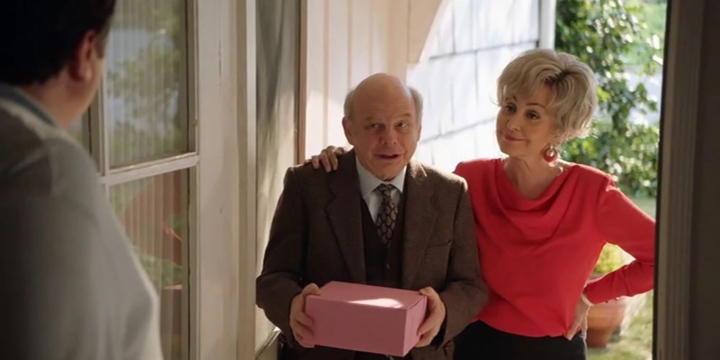 Connie and Dr. Sturgis standing at the front door with cake in Young Sheldon.