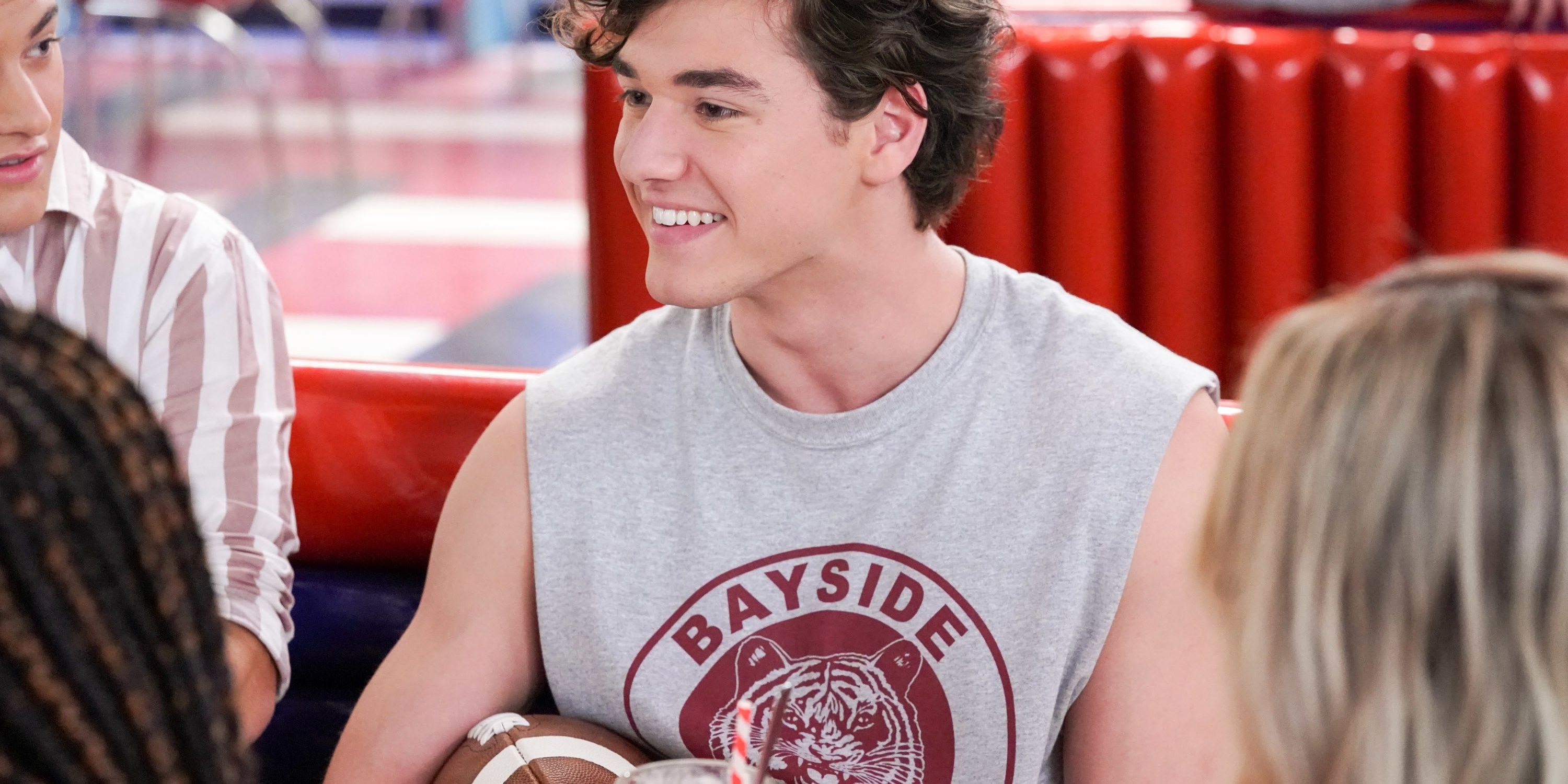 Jamie Spani holding a football and smiling in Saved By The Bell Cropped 1