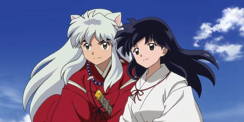 Inuyasha and Kagome standing next to each other with slight smiles and a blue sky behind them.