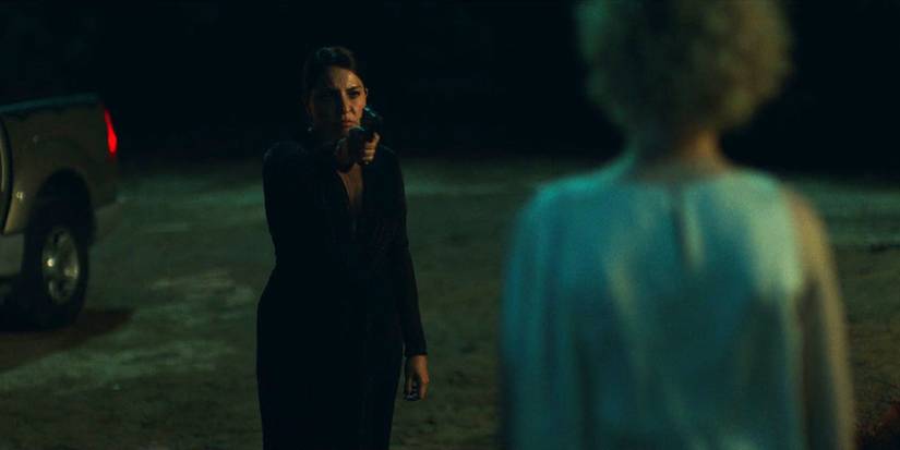 Camila (Veronica Falcon) aiming a gun at Ruth Langmore (Julia Garner) in Ozark