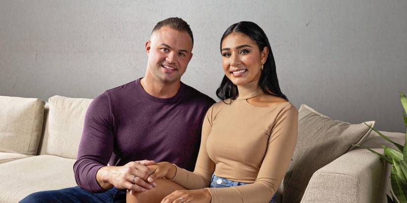 Patrick Mendes and Thaís Ramone from 90 Day Fiancé season 9 smiling while sitting on the couch
