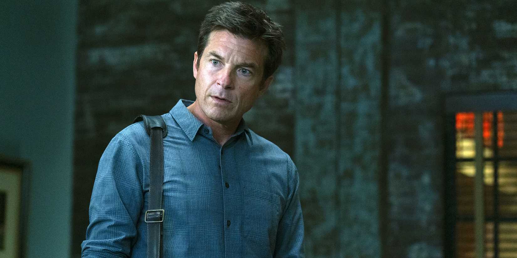 Marty Byrde (Jason Bateman) looking surprised as he stands in a dark room in Ozark.