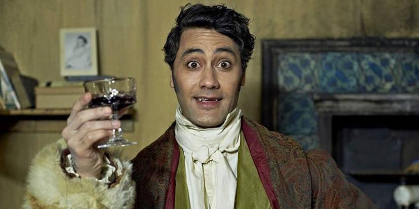 Viago (Taika Waiтιтi) holds up a glᴀss of wine in What We Do in the Shadows