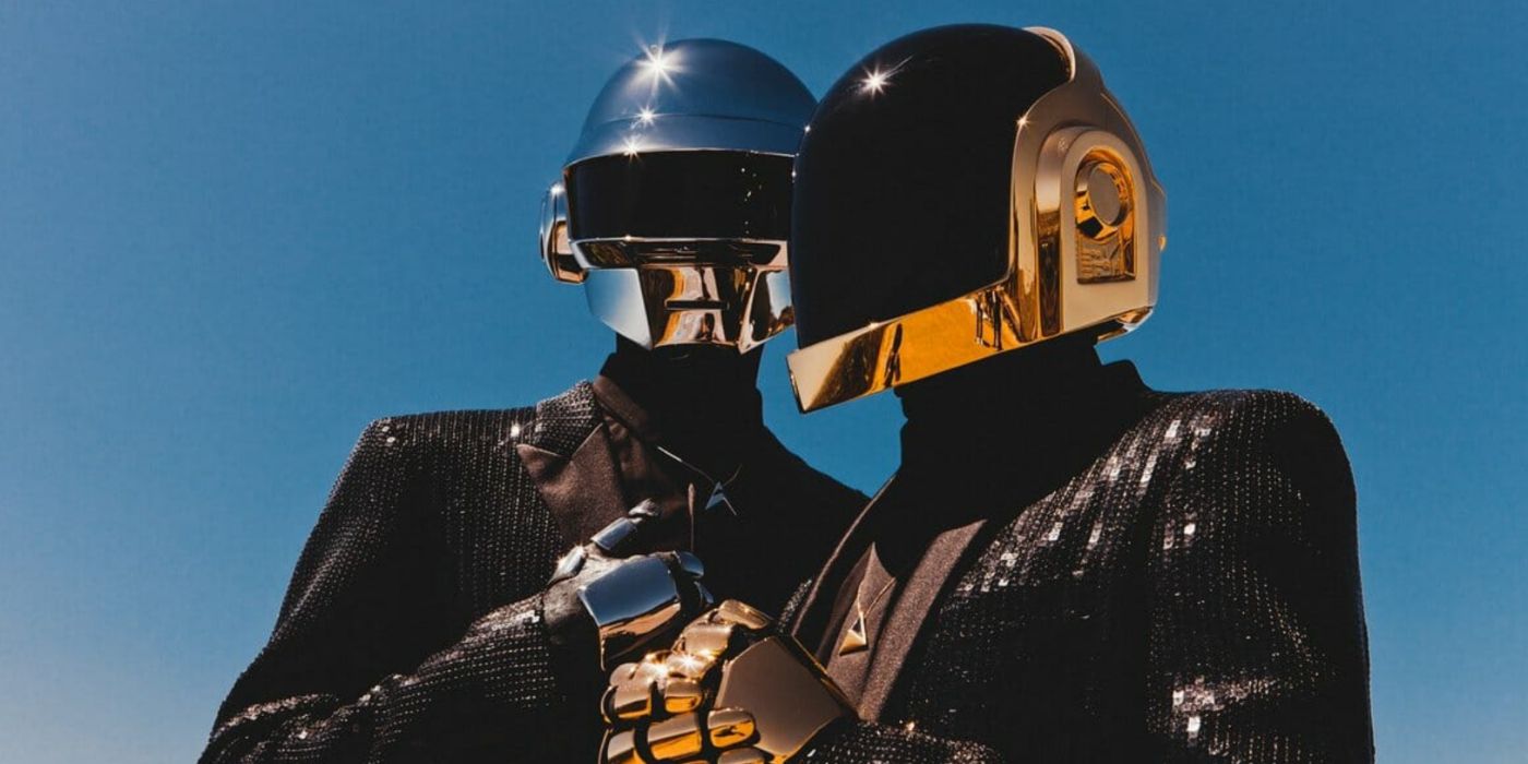 Daft Punk in metallic helmets in front of a blue sky.