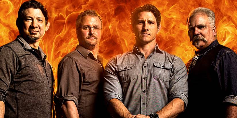 The Forged In Fire judges and hosts standing in front of a fiery background.