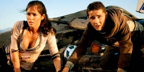 Transformers' Shia Labeouf and Megan Fox looking up with wreckage behind them 