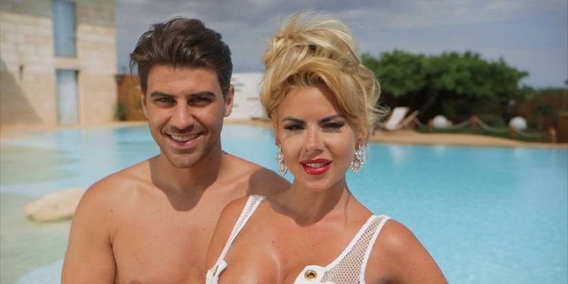 hannah and jon posing in front of the pool in the love island villa