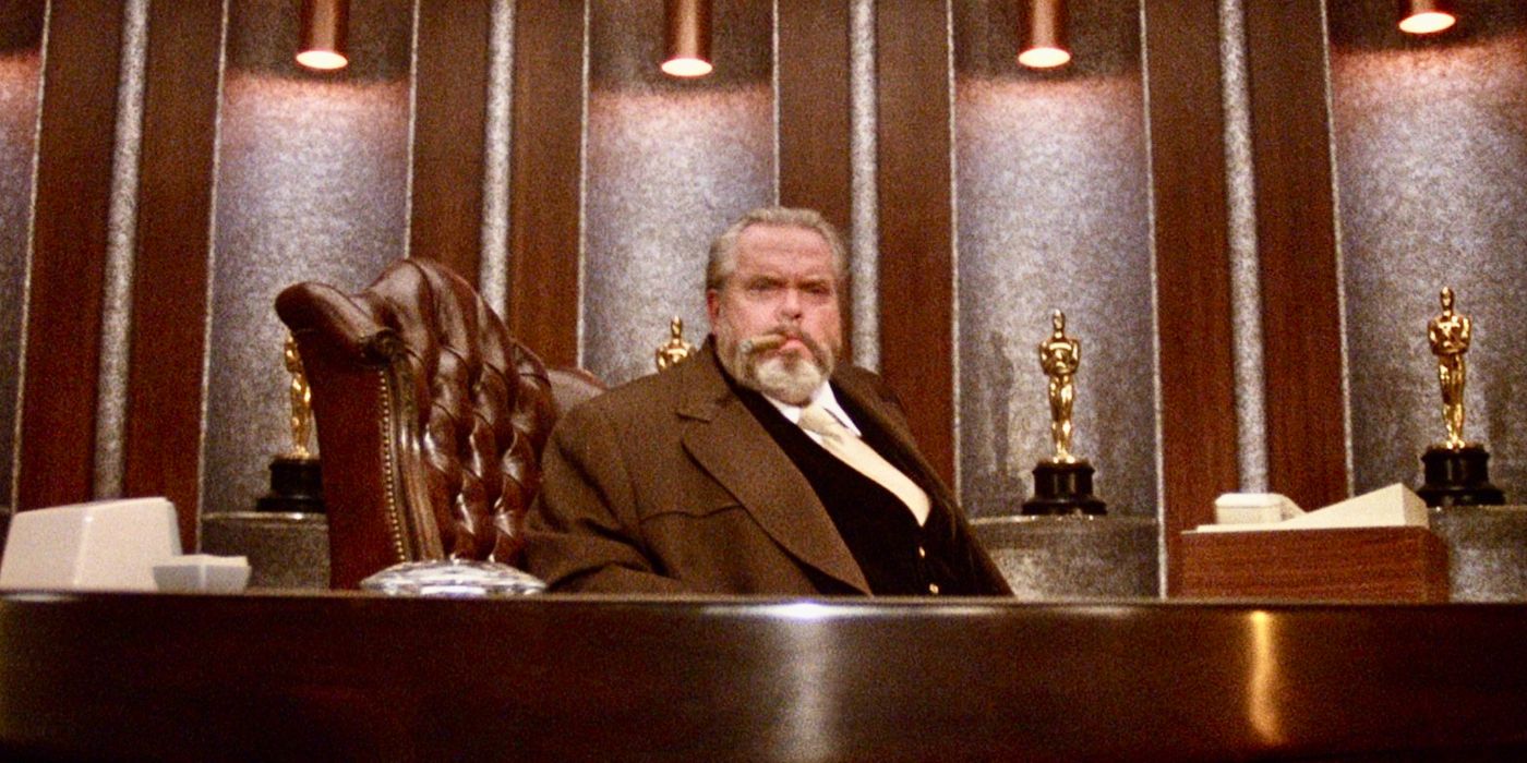 Orson Welles sitting at a big desk in the Muppet movie.