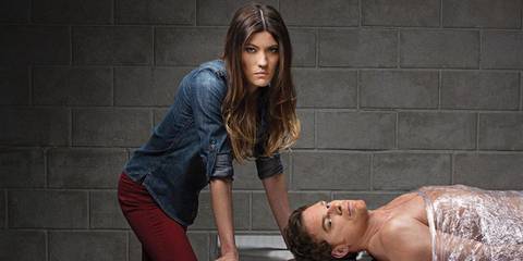 Debra standing over Dexter on a slab in Dexter