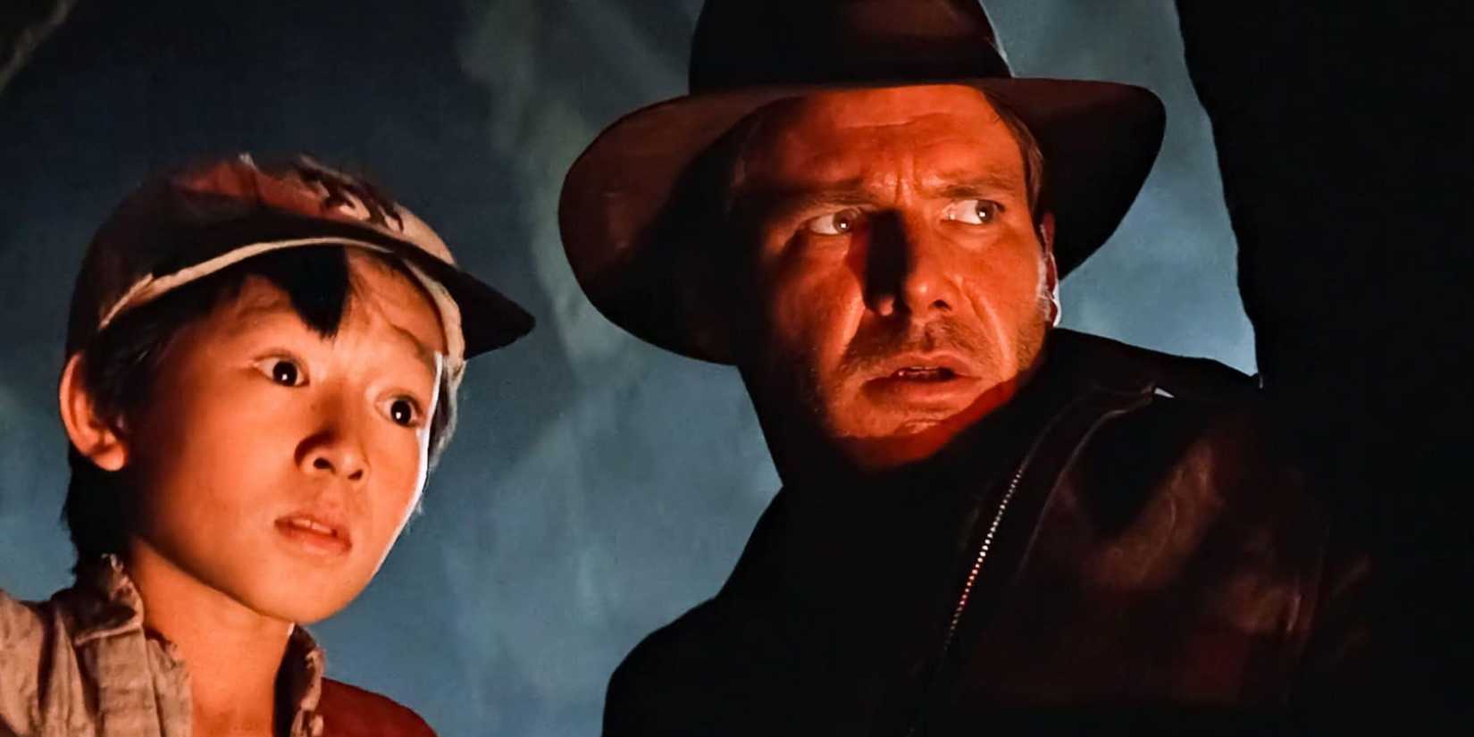 Ke Huy Quan as Short Round and Harrison Ford as Indy looking concerned in The Temple of Doom