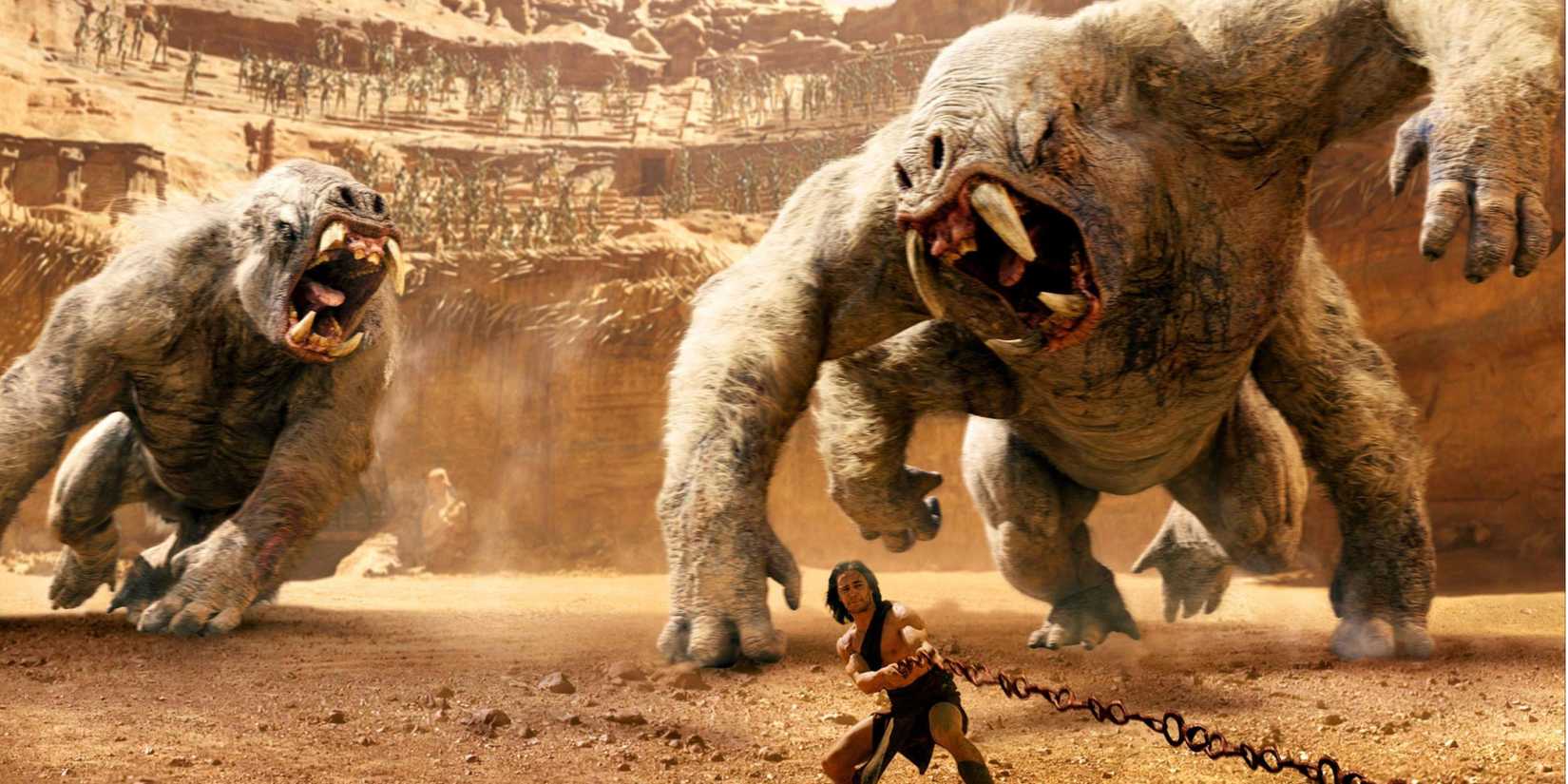John Carter (Taylor Kitsch) a punto de arrojar una roca a las gigantescas bestias marcianas en John Carter.
