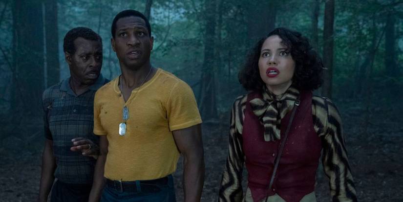 Three characters in Lovecraft Country standing in the woods, looking surprised