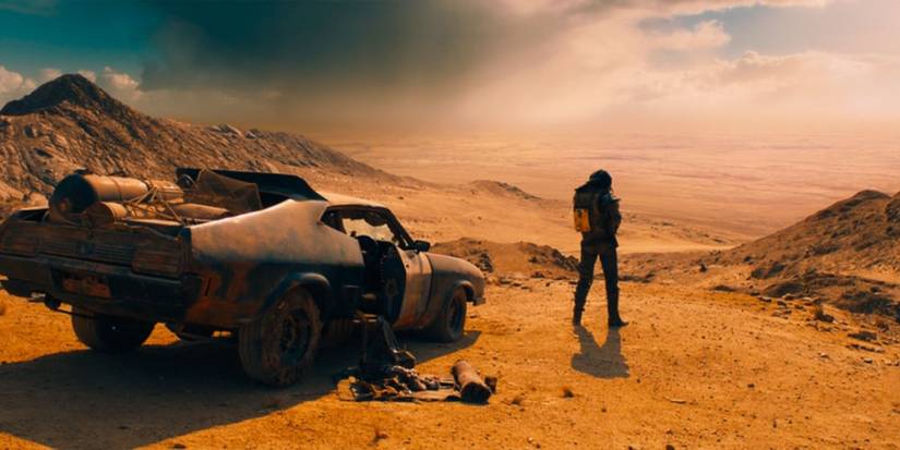 Tom Hardy as Max Rockatansky stands in front of his car in the opening of Mad Max: Fury Road.