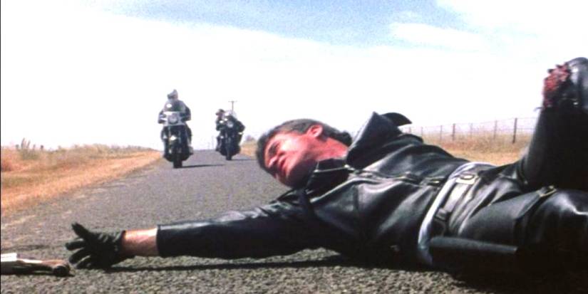 Mel Gibson as Mad Max reaching for his gun in Mad Max 1979