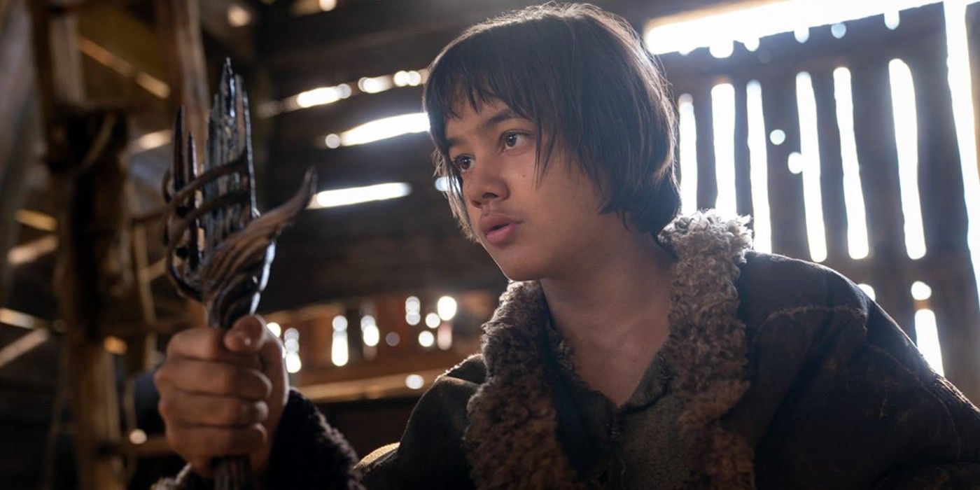 Tyroe Muhafidin as Theo holding black sword in The Lord of the Rings: The Rings of Power.