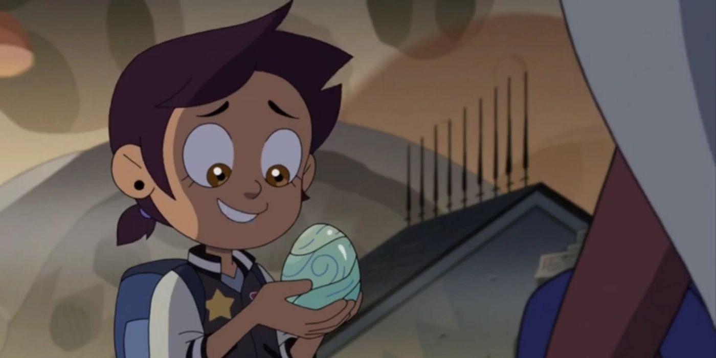 Image of Luz smiling at the palisman egg in her hands