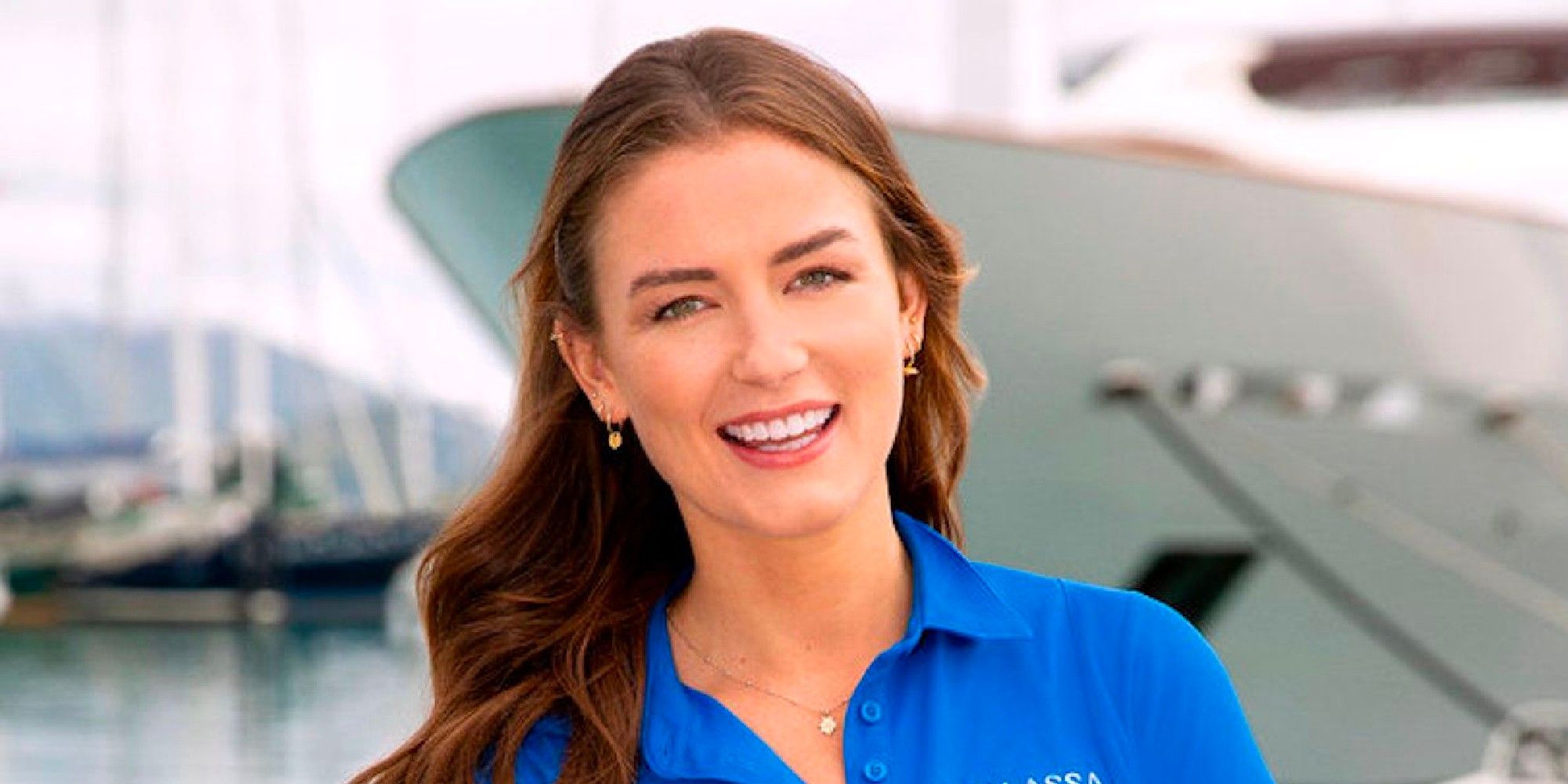 Aesha Scott from Below Deck Down Under's promo photo wearing blue shirt in front of yacht