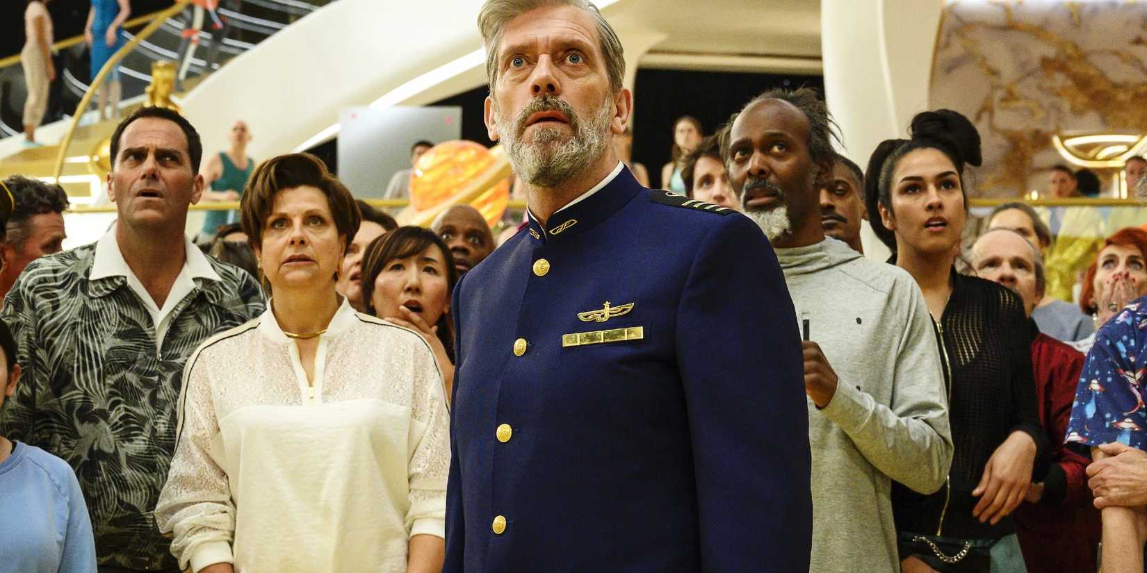 Hugh Laurie standing in front of a crowd looking concerned in Avenue 5