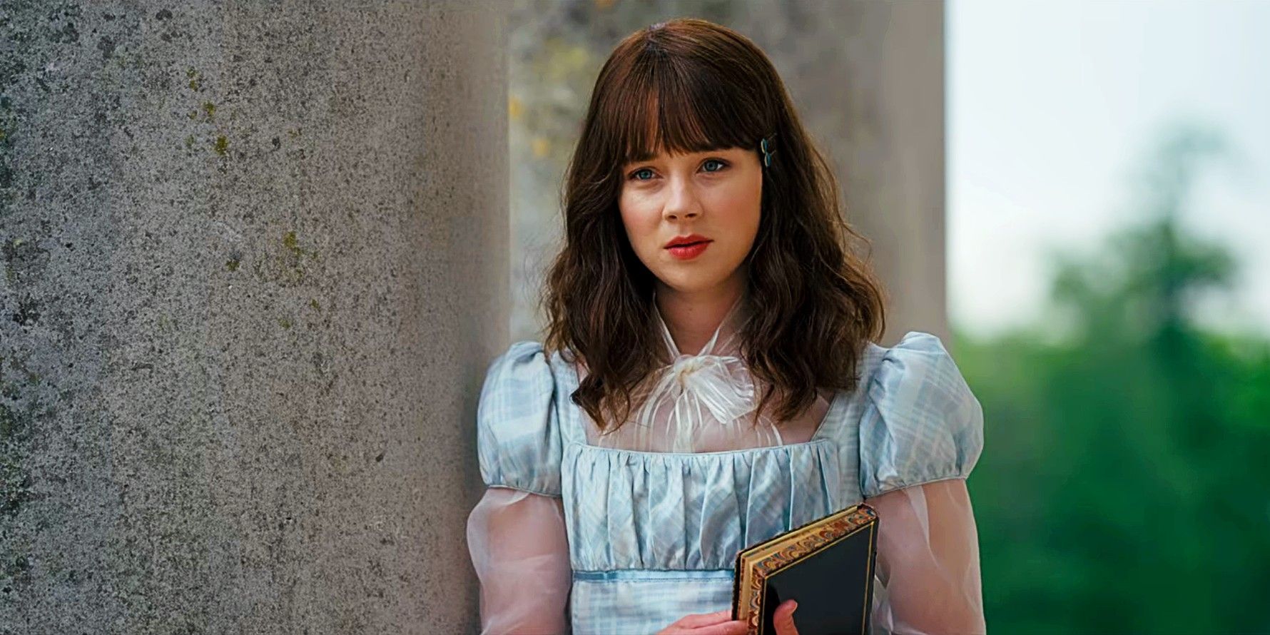 Claudia Jessie as Eloise Bridgerton in Bridgerton season 2 holding book