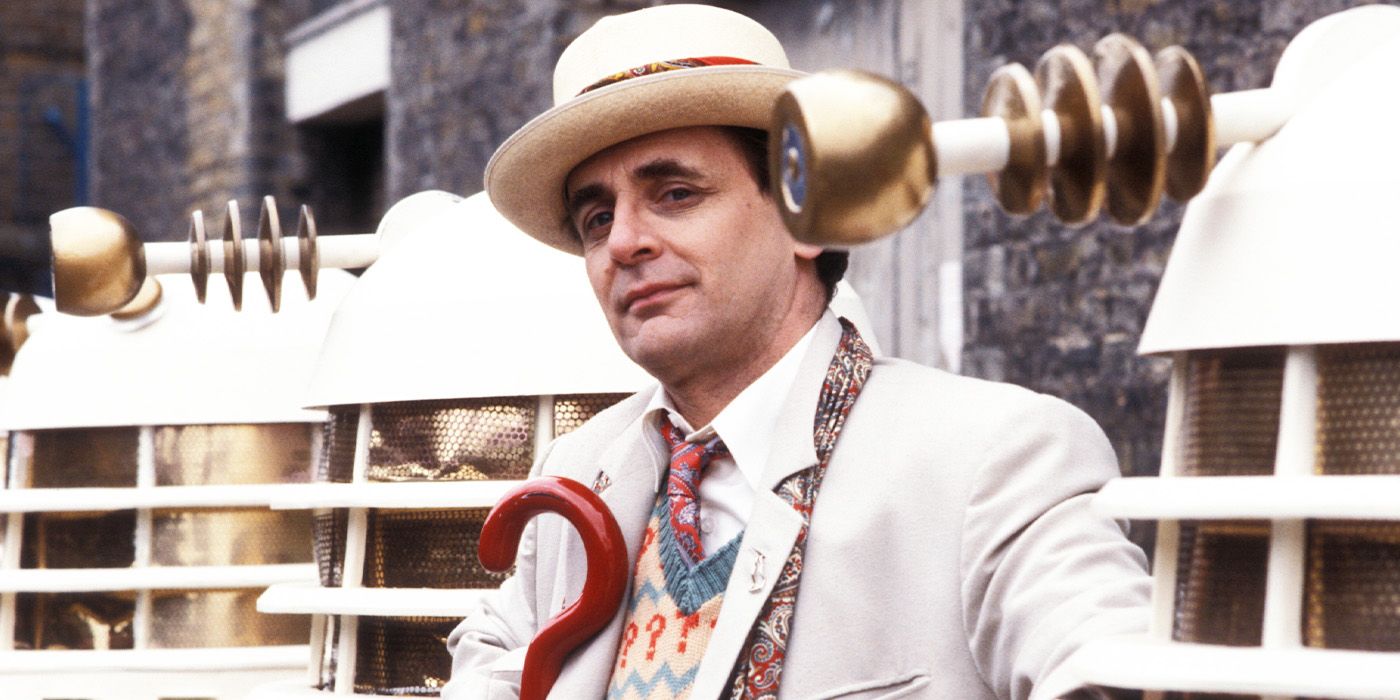 Seventh Doctor Sylvester McCoy standing next to the Daleks in Doctor Who