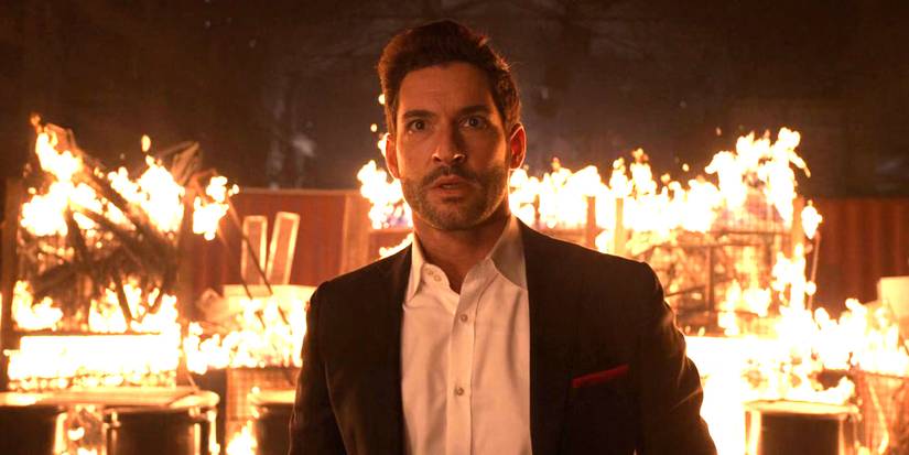 Tom Ellis as Lucifer standing in front of a burning room in season 6's finale