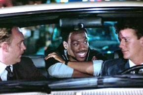 John Asthon as John Taggart, Eddie Murphy as Axel Foley, and Judge Reinhold as Billy in a car in Beverly Hills Cop.
