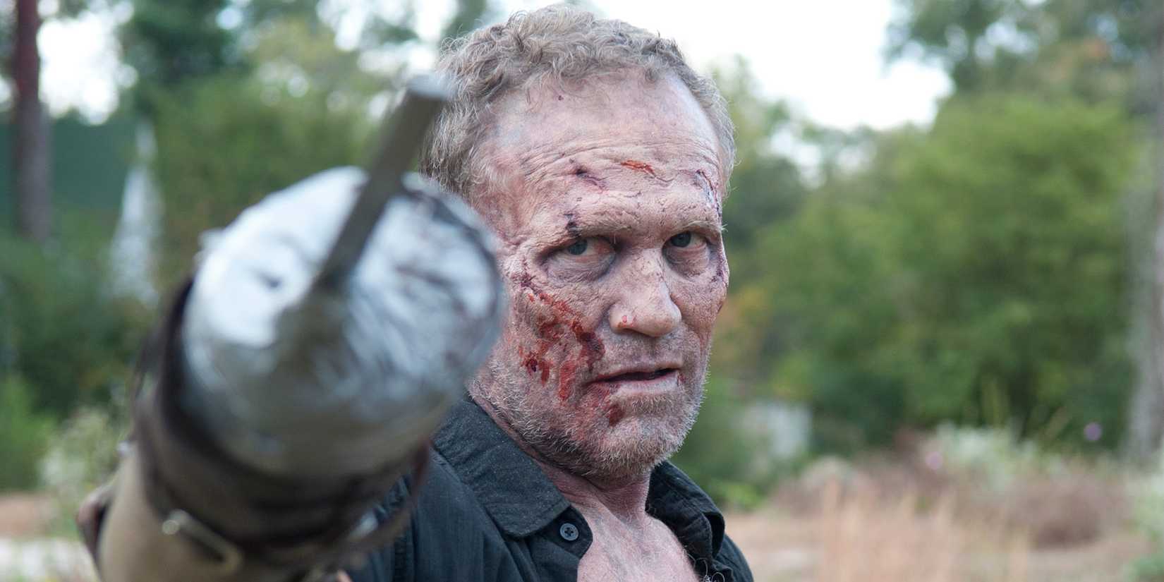 Michael Rooker as Merle Dixon with wounds on his face and pointing his modified hand towards the camera in The Walking Dead Season 3 Episode 15 "This Sorrowful Life"