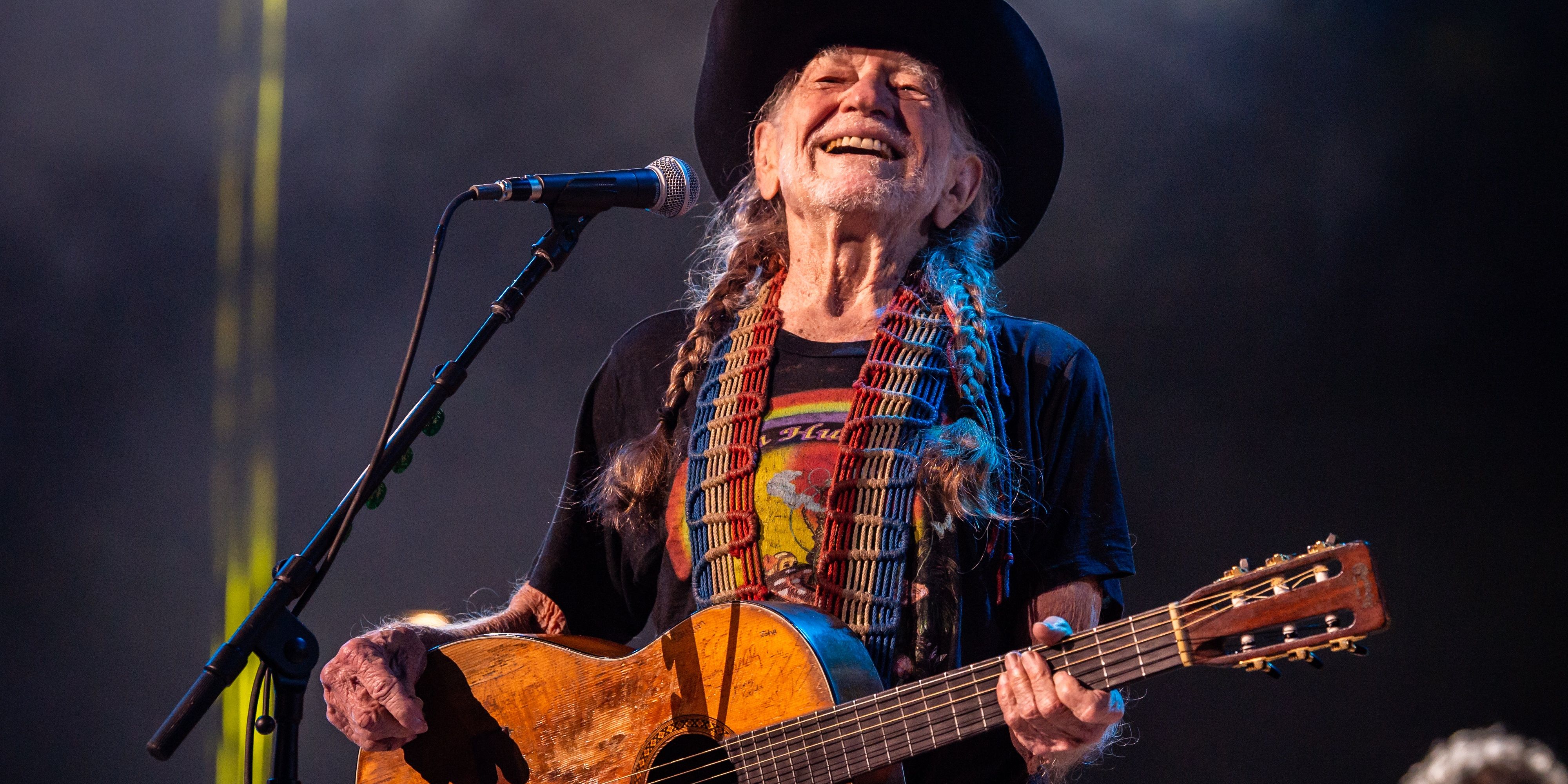 Willie Nelson tocando violão em apresentação