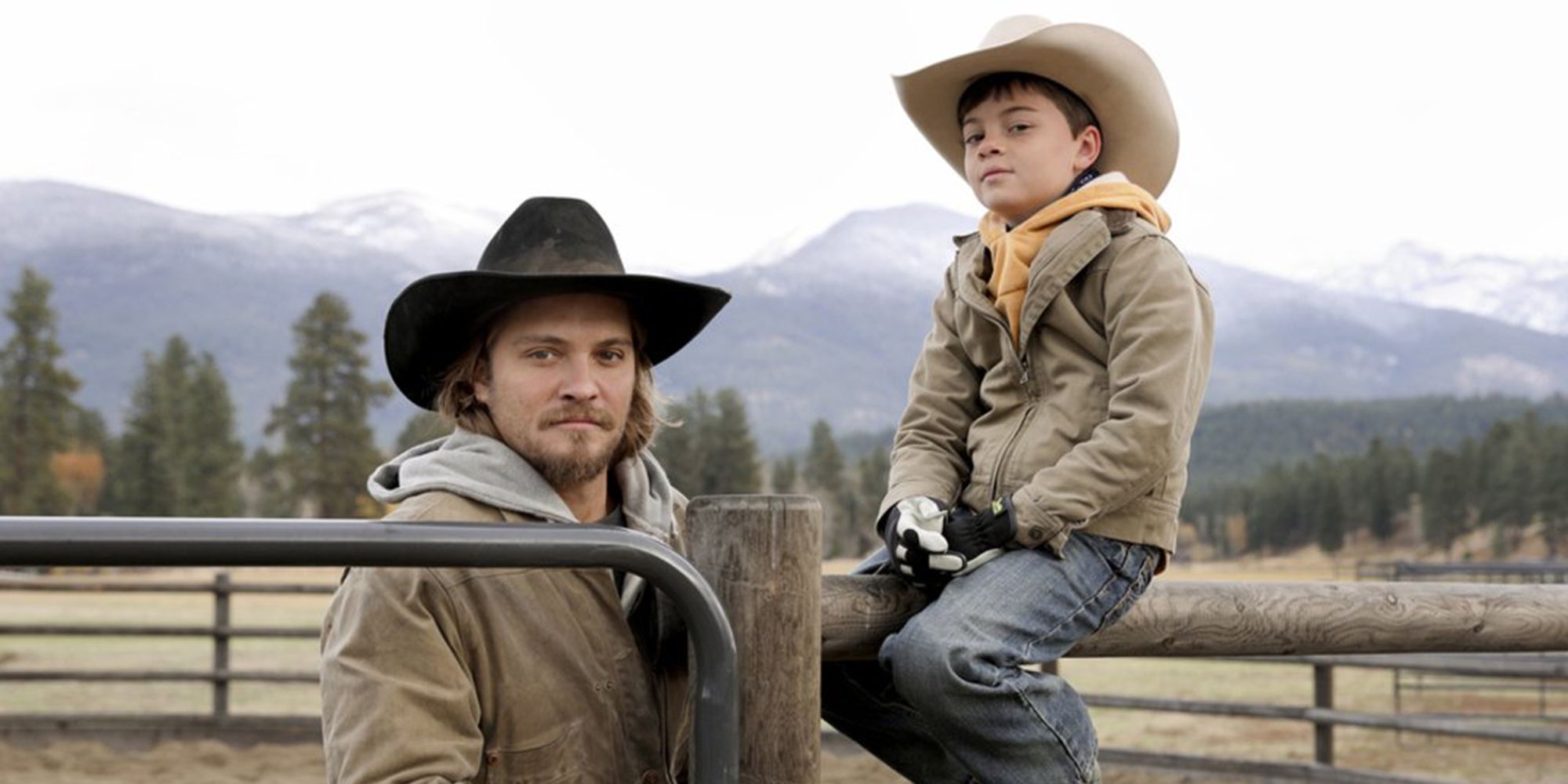 Kayce and Tate by a fence in Yellowstone.