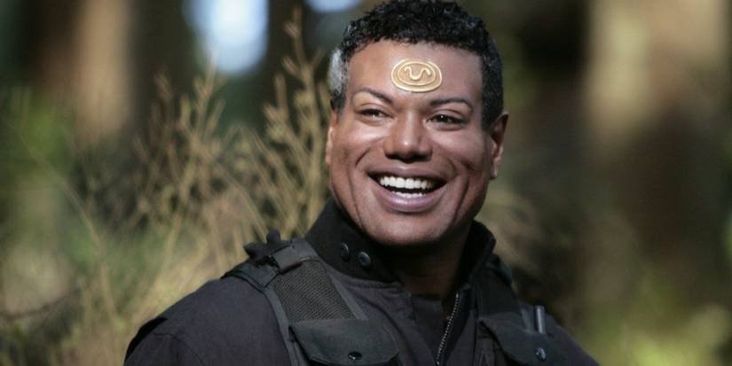 Christopher Judge smiling wearing tactical gear and smiling.