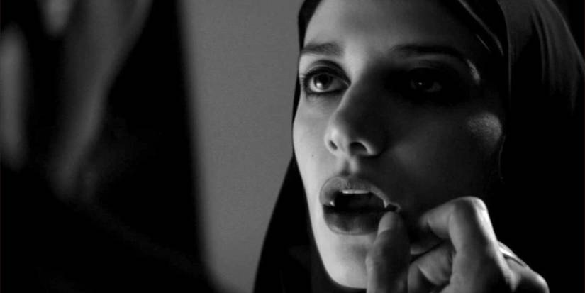 The Girl (Sheila Vand) barring her fangs at someone in A Girl Walks Home Alone At Night