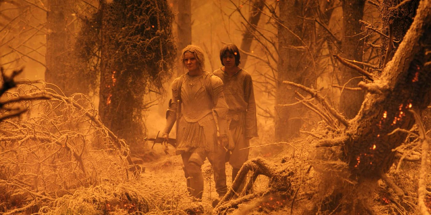 Morfydd Clark and Tyroe Muhafidin as Galadriel and Theo walking through ash in Rings of Power.