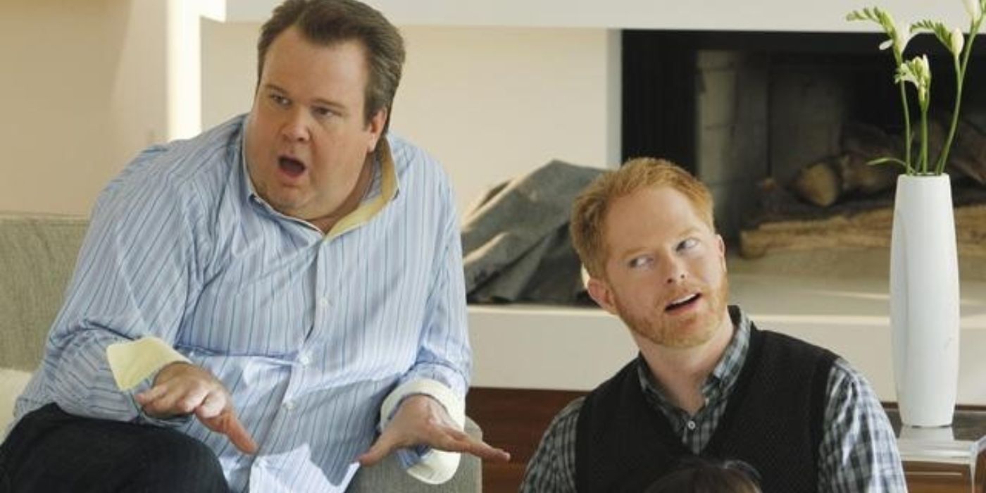 Mitch dan Cam menggendong Lily di atas karpet mahal di Modern Family