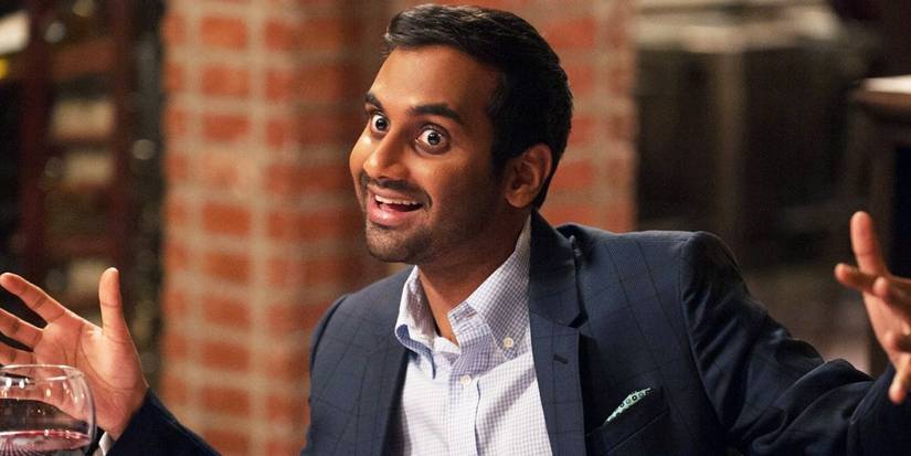 Tom Haverford Smiling with His Hands Raised to the Sides in Parks and Rec