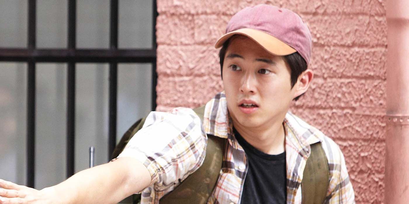 Steven Yeun as Glenn from season 1 of The Walking Dead, wearing a baseball hat and backpack.