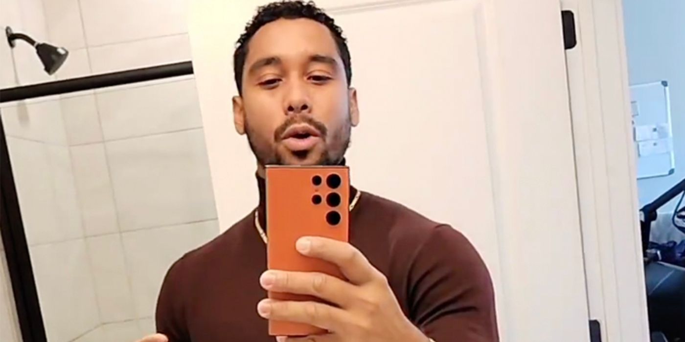 Pedro Jimeno from The Family Chantel holding phone wearing brown shirt taking a mirror selfie