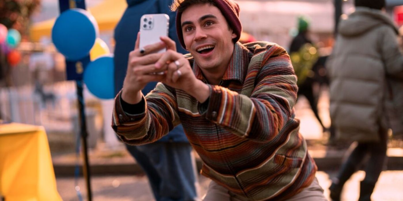 Carlos sorrindo e tirando foto com o celular na Blockbuster